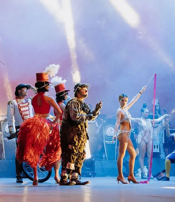 sinopsis01 escena de el circo de la ultima estrella con bailarinas, bastoneras, un payaso vagabundo artistas acrobatss y luces